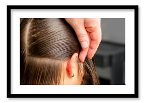 Hairdresser divides female hair into sections with comb holding hair with her hands in hair salon close up