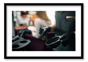 Close-up of hairdresser mixing dye in a container at hair salon.