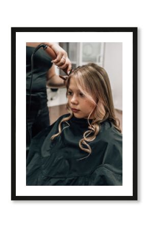 beautiful girl curls at the stylist in the hairdresser