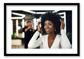 Young african woman customer getting a hairstyle at a beauty salon.