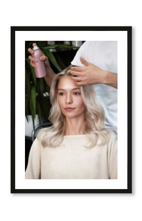 Young woman in a hairdressing salon dyes her hair blond