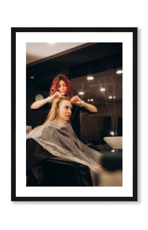 Young woman in a hairdressing salon dyes her hair blond and washing head.