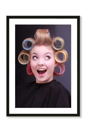 Funny blond girl hair curlers rollers by hairdresser in salon