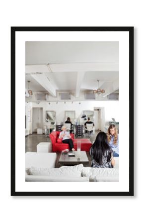 Client Having Manicure With People Waiting In Salon