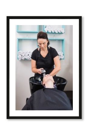 Hairdresser washing clients hair