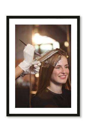 Hairdresser dyeing hair of her client