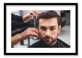 Skillful hairdresser cutting male hair