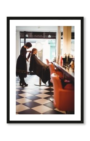Female hairdresser styling clients hair