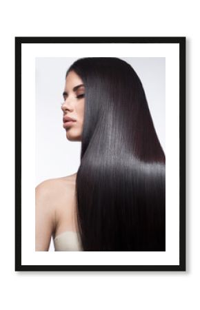 Beautiful brunette girl in move with a perfectly smooth hair, and classic make-up. Beauty face. Picture taken in the studio on a white background.