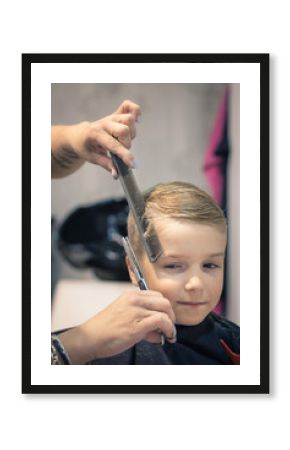 Cute boy getting a haircut at the salon.