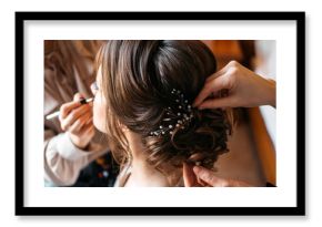 A hair stylist and make-up artist prepare a bride for the wedding day