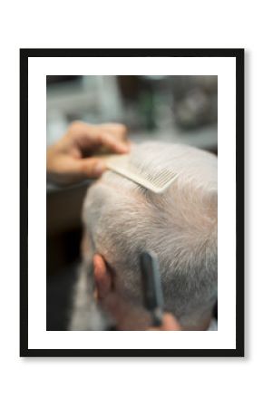Combing hair elderly male in barbershop