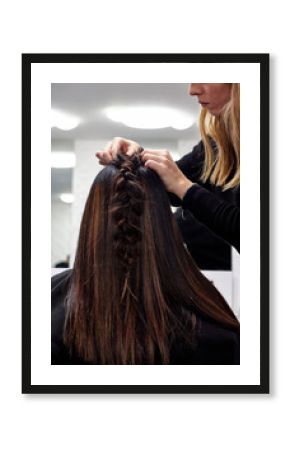 Hairdresser makes braid to client