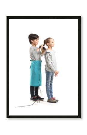 Cute little hairdresser doing hair of girl on white background