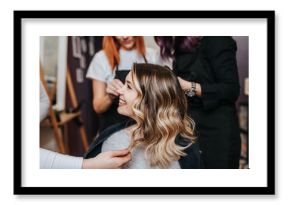 Beautiful hairstyle of young woman after dyeing hair and making highlights in hair salon.