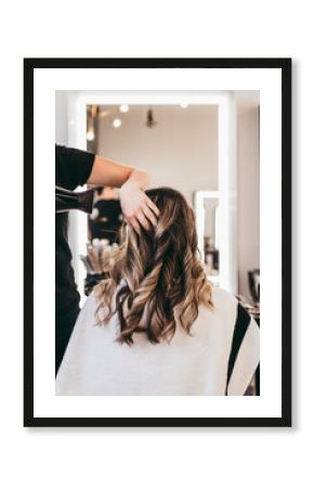 Beautiful brunette woman with long hair at the beauty salon getting a hair blowing. Hair salon styling concept.