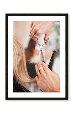 Hairdresser cutting hair for young blonde woman
