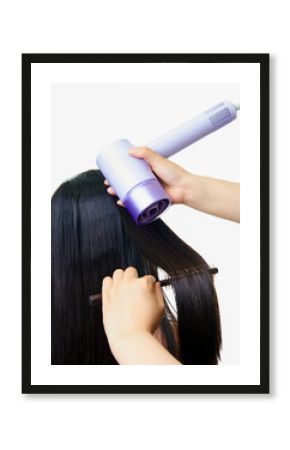 Makeup artist using comb and hair dryer to blow dry girl's hair