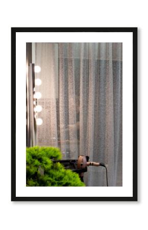 Close up of the detail of interior of a modern hair salon: mirror with lightening and hair dryer (