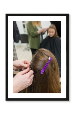 Teenager having hair braided at the hairdresser