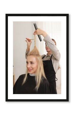 Hairdresser cutting client's hair with scissors in salon