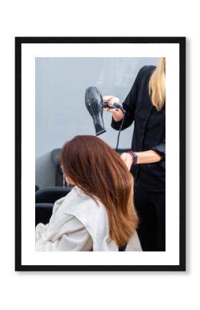 Hairstylist blow drying clients hair with a fan