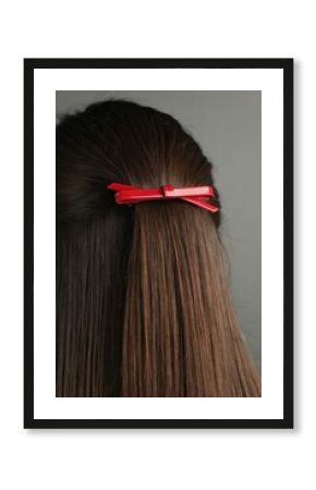 Woman with beautiful hair clip on grey background, back view