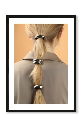 Woman with beautiful hair ties on beige background, back view