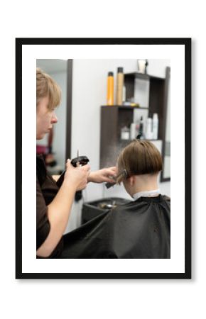 Hair stylist trims a child's hair in a modern salon setting during a busy afternoon