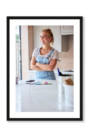 Portrait Of Smiling Woman Renovating Kitchen At Home Looking At Paint Swatches On Coffee Break