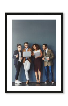 Staying connected for better productivity. Studio shot of a group of businesspeople using wireless technology together while standing in line against a gray background.