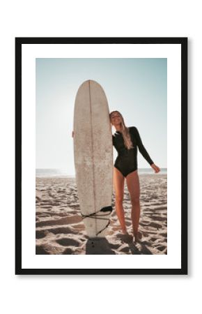 young woman standing with surfboard at Malibu beach. california lifestyle