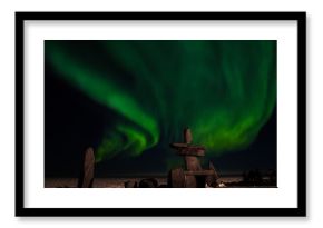 the aurora borealis, behind an inuit structure, with photographers enjoying the northern lights.