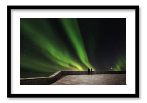 Couple enjoying beautiful Aurora Borealis at night