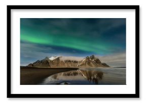Paisagem nocturna na Islândia. Surpreendente Aurora Boreal na montanha de Vestrahorn com dunas de areia preta, em Stokksnes, Islândia