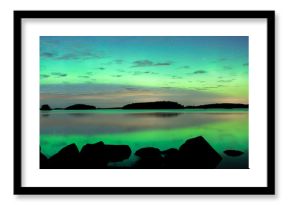 Northern lights dancing over calm lake in Farnebofjarden national park in Sweden.