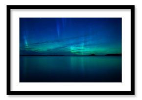 Northern lights dancing over calm lake in Farnebofjarden national park in Sweden