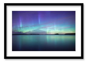 Northern lights dancing over calm lake in Farnebofjarden national park in Sweden