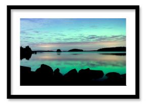 Northern lights dancing over calm lake. Farnebofjarden national park in Sweden.