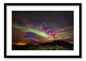 Aurora borealis being a wind turbine generator on top of a hill