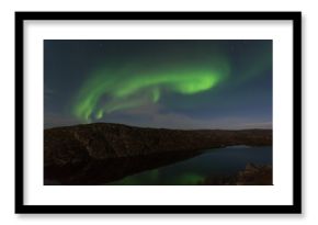 Northern lights, aurora in autumn over the lake.