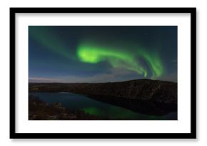 Northern lights, aurora in autumn over the lake.