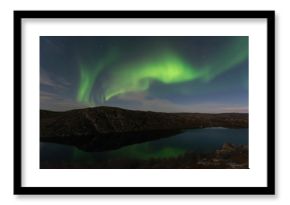 Northern lights, aurora in autumn over the lake.