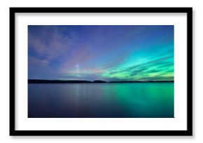 Northern lights dancing over calm lake 