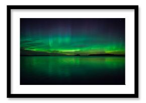 Northern lights dancing over calm lake 