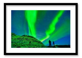 View of the northern light with photographers expecting near Kirkjufell Mountain in Iceland.