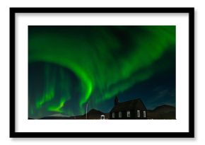 Northern Lights over The Black Church Budir, Iceland. Aurora Borealis in an amazing nightscape. Travel destination with beautiful green lights landscape.