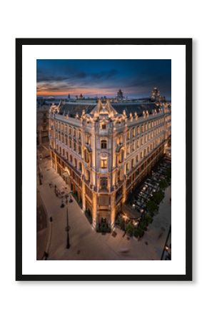 Budapest, Hungary - Aerial view of a renovated illuminated luxury collection hotel near Ferenciek tere after sunset at downtown Budapest with colorful golden and blue sky on a summer night