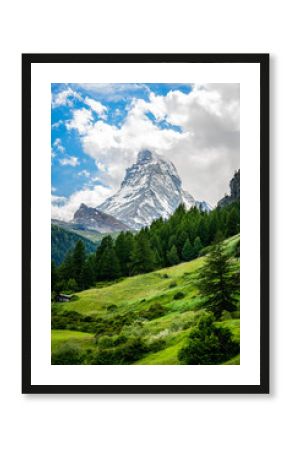 Vertical scenic view of the Matterhorn mountain summit with snow clouds blue sky and nature during summer in Zermatt Switzerland