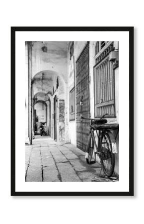 Monochrome photo of retro bicycle in a narrow alley, old town